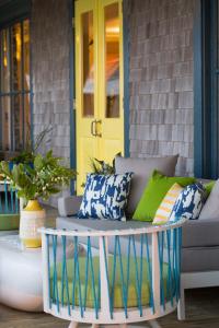 a porch with a couch and a yellow door at Summercamp in Oak Bluffs