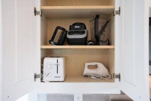 a cupboard with a kitchen appliances in it at Live Oak Cottage OKI Beach Retreat in Oak Island