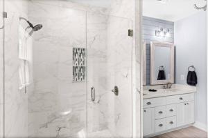 a white bathroom with a shower and a sink at Live Oak Cottage OKI Beach Retreat in Oak Island +18 photos