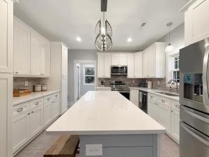 a kitchen with white cabinets and a white counter top at Live Oak Cottage OKI Beach Retreat in Oak Island