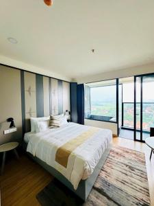 a bedroom with a large bed and a large window at Lynntime in La Phu