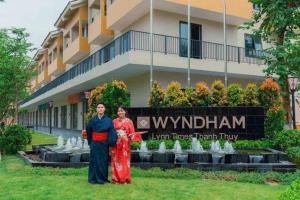 a man and a woman standing in front of a building at Lynntime in La Phu