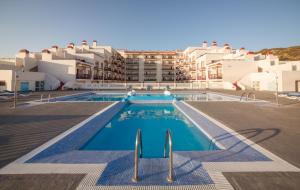 a view of a swimming pool with buildings in the background at Apartamentos Centro Cancajos in Los Cancajos