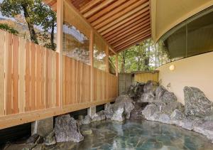 a house with a pool of water with rocks at Marumine Kanko Hotel in Aizuwakamatsu