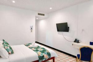 a hotel room with a bed and a tv on the wall at Crown Royale Hotel & Lounge in Port Vila