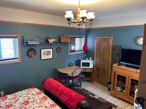 a room with a bed and a table with a television at Chez Odette, loft intime in Roberval