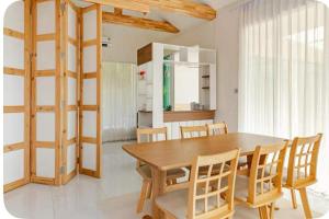 a dining room with a wooden table and chairs at Japanese house PhuSaimorkVilla in Ban Kai Noi