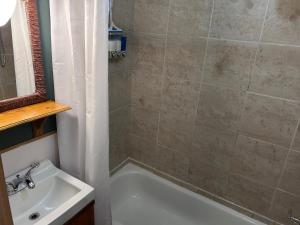 a bathroom with a bath tub and a sink at Chez Odette, loft intime in Roberval