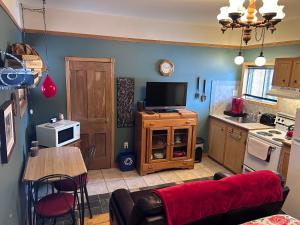 a living room with a tv and a kitchen at Chez Odette, loft intime in Roberval +4 photos
