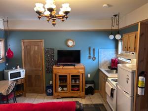 a kitchen with a tv on a wooden cabinet at Chez Odette, loft intime in Roberval