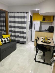 ein Wohnzimmer mit Sofa und Tisch und eine Küche in der Unterkunft LP House in Bicas