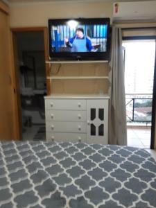 ein Schlafzimmer mit einem Fernseher auf einer Kommode in der Unterkunft LP House in Bicas