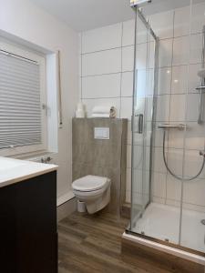 a bathroom with a toilet and a glass shower at Hotel Zur Post in Haren +33 photos