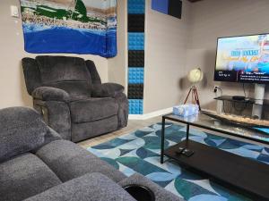 a living room with a couch and a chair and a tv at Stromberg Court in Saskatoon