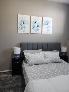 a bedroom with a bed with three pictures on the wall at Stromberg Court in Saskatoon