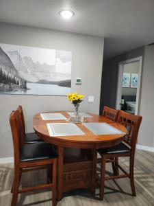 a dining room table with a vase of flowers on it at Stromberg Court in Saskatoon