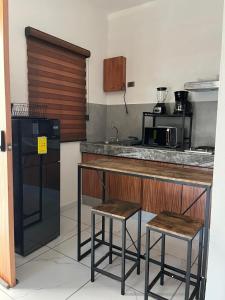 a kitchen with two stools and a counter in a kitchen at Valle Stay in Cedro