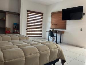 a room with a bed with a flat screen tv at Valle Stay in Cedro