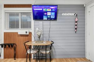 a room with a table and a tv on the wall at Secluded Bachelor Suite in Vancouver
