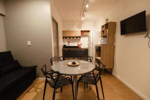 a living room with a table and chairs and a kitchen at P&G Apto 203-Bagnoregio in Caxias do Sul