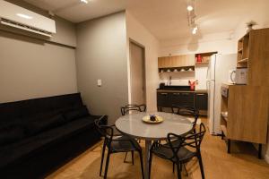 a living room with a table and chairs and a couch at P&G Apto 203-Bagnoregio in Caxias do Sul