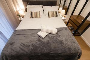 a bed with two towels sitting on top of it at P&G Apto 203-Bagnoregio in Caxias do Sul +6 photos