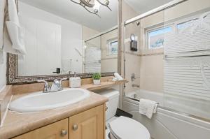 a bathroom with a sink and a toilet and a tub at Secluded Bachelor Suite in Vancouver +17 photos
