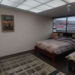 a bedroom with a bed and a window at Departamento MEDIO DIA in Quito