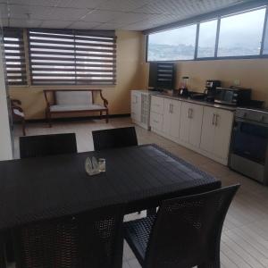 a kitchen with a table and chairs in a room at Departamento MEDIO DIA in Quito