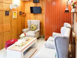 a living room with chairs and a table and a tv at Roemah Djogja Inn Seturan Raya RedPartner in Seturan