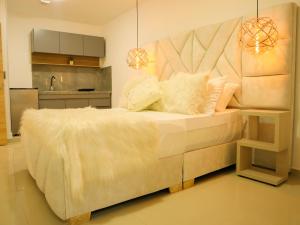 a bedroom with a large bed and a kitchen at Santa Barbara Central Suites in Bogotá +12 photos