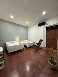 a room with two beds and a table and chairs at Hostal El Amate #2 in Suchitoto +5 photos