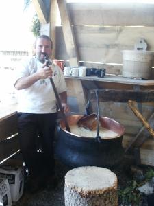 a man standing next to a large pot of food at Hotel Blümlisalp in Grindelwald