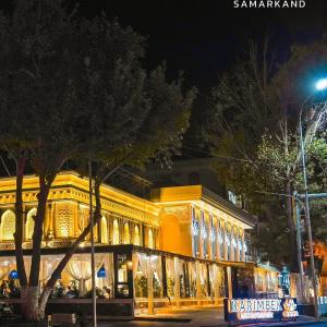 a large building with lights on it at night at Karimbek Guest house by SamApart in Samarkand
