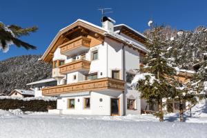 een groot wit gebouw in de sneeuw bij Residence Telemark in Santa Cristina in Val Gardena