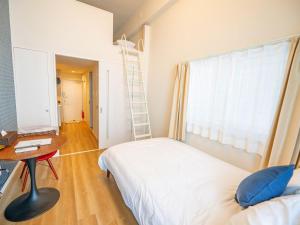 a bedroom with a bed and a desk and a ladder at Hotel Tomas Asahibashi Station in Naha