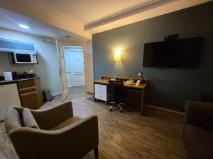 a hotel room with a desk and a computer on the wall at Flat Hotel Executivo Vila Olímpia (Apto 2509) in São Paulo