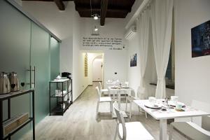 una sala da pranzo con tavoli bianchi e sedie bianche di Parthenope Suite a Napoli