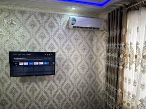 a flat screen tv hanging on a wall at Karimbek Guest house by SamApart in Samarkand +13 photos
