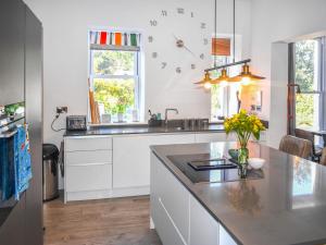 a kitchen with white cabinets and a counter top at Cedars in Mortehoe +10 photos