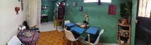 a room with a table and chairs and a green wall at Casamar in Cobán