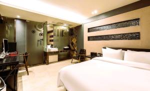 a bedroom with a bed and a desk with a computer at Hip Hotel in Seoul