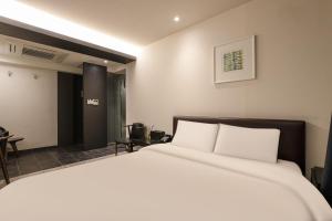 a bedroom with a large bed with white pillows at Hip Hotel in Seoul