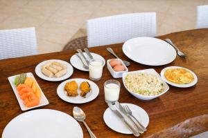 a wooden table with white plates of food on it at The Pade Dive Resort in Sabang
