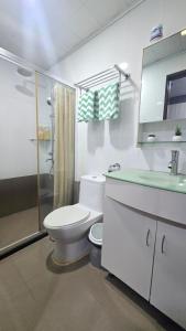 a white bathroom with a toilet and a shower at The Highland Condotel in Baguio +19 photos