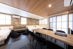 a room with a table and chairs and a couch at WeskiiHotel in Kanazawa