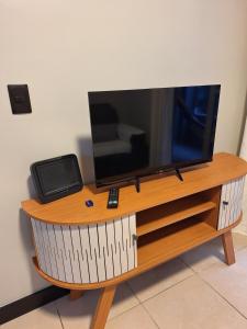 a flat screen tv sitting on top of a wooden entertainment center at Apto 3 dorms proximo a UFABC e CPTM in Santo André