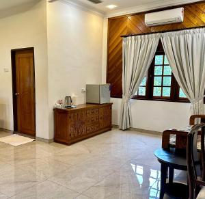 a living room with a tv and a window at Astana Az-Zahrah in Bahau