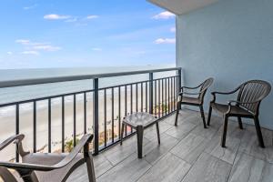 a balcony with chairs and a view of the beach at Oceanfront,Heated Pools,Boardwalk, Location,Views! in Myrtle Beach