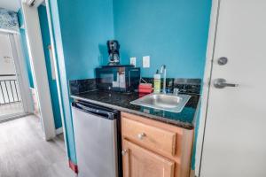 a small kitchen with a sink and a counter at Oceanfront,Heated Pools,Boardwalk, Location,Views! in Myrtle Beach